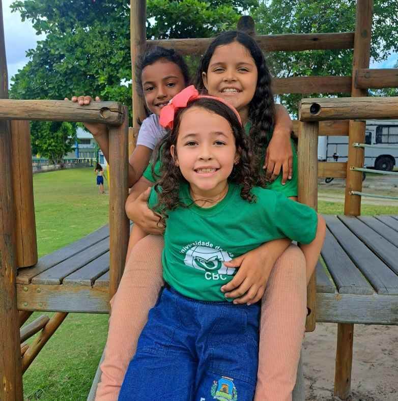 three girls sitting together on the playground