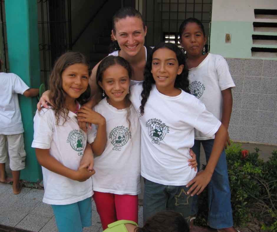 Volunteer with four cbc students in front of classroom building