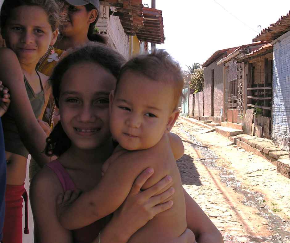 family in the shade of a wall in dirt street