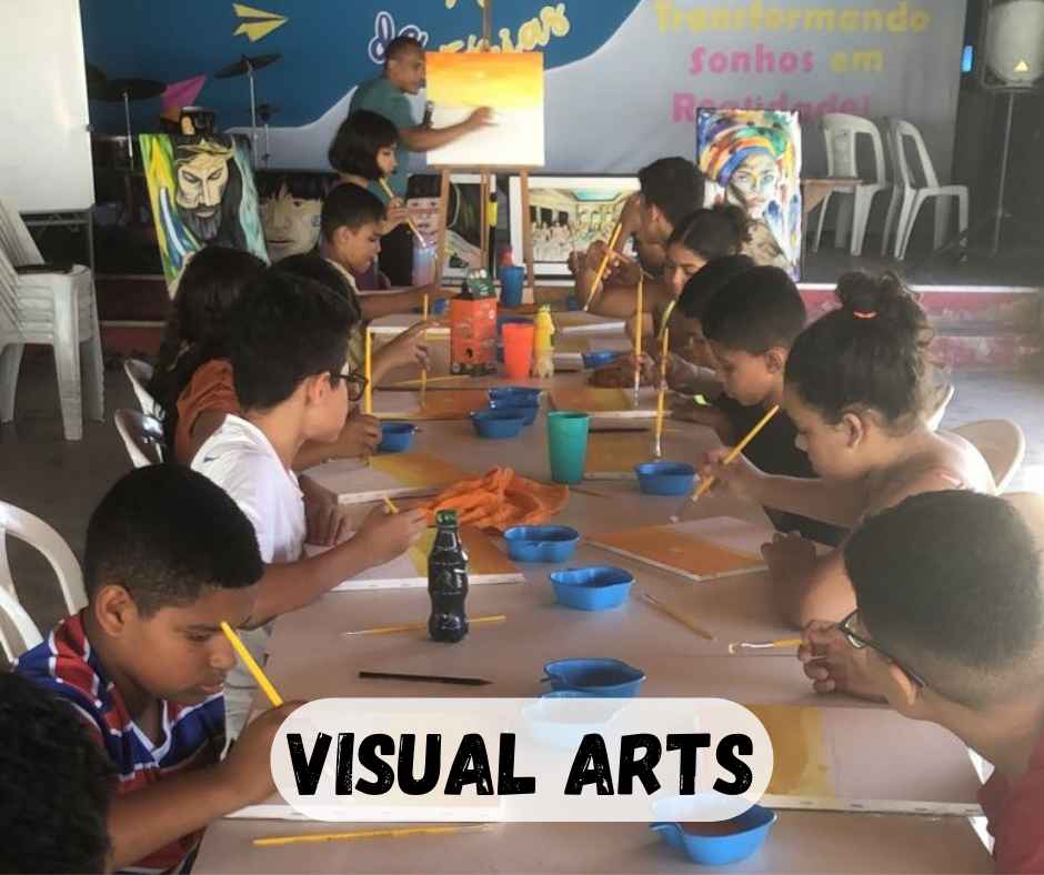 4th grade class painting with teacher demonstrating at the end of the table